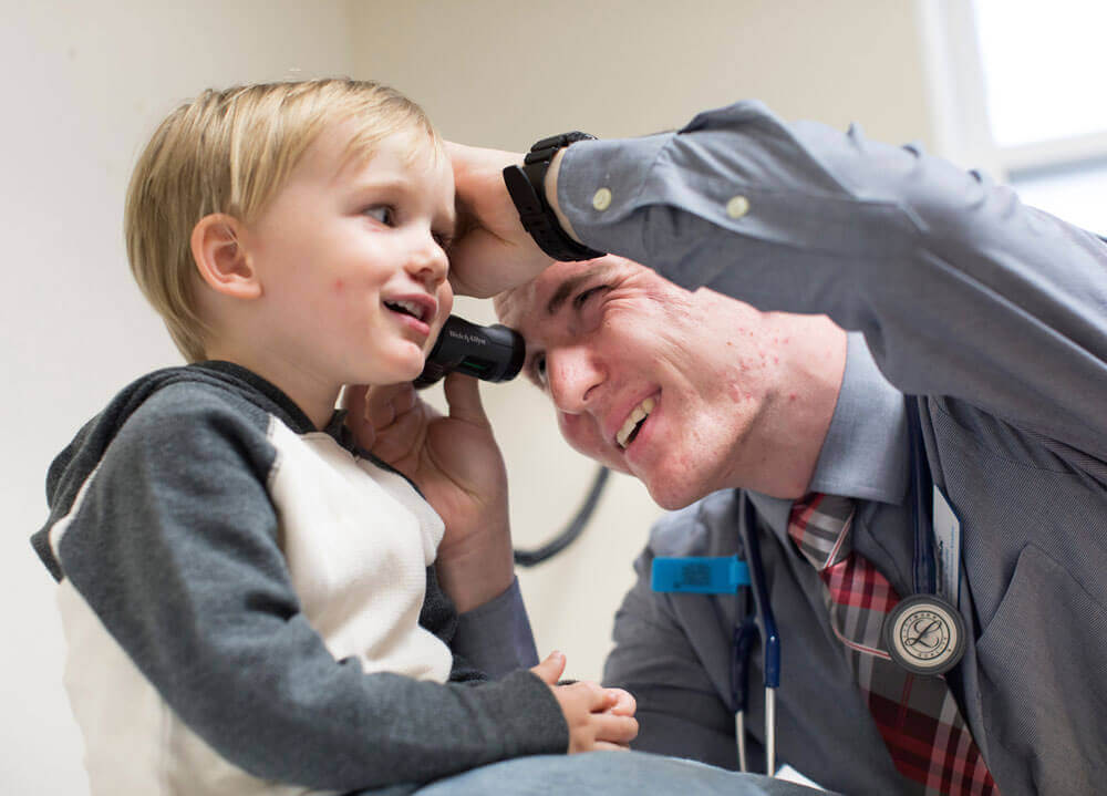 A student examines a toddler's ear