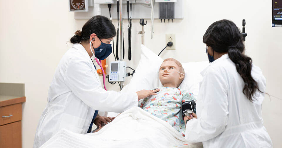 Two accelerated nursing students practice their clinical skills