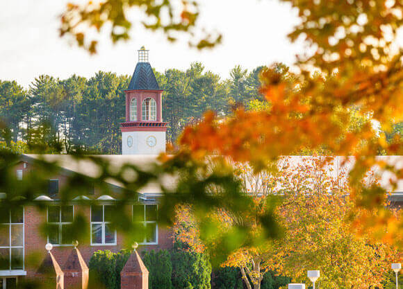 The clocktower peaking over a building.