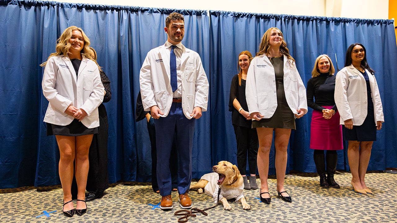 Students pose with dog at White Coat Ceremony