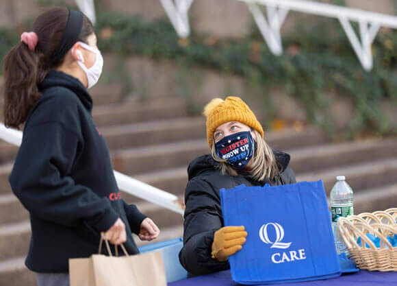 Students in masks talk outside socially distanced