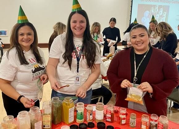 Three individuals pose at a soup station