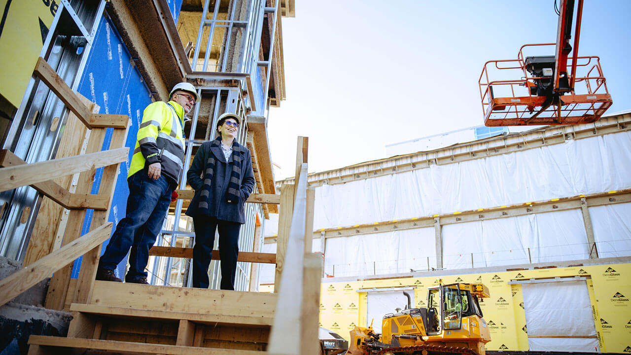 A construction worker speaks with Debra Liebowitz about the South Quad construction.