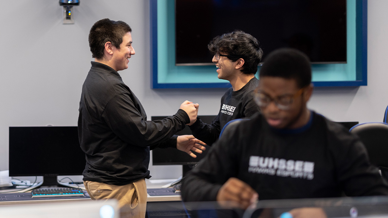 eSports athletes shake hands and congratulate one another with smiles on their faces.