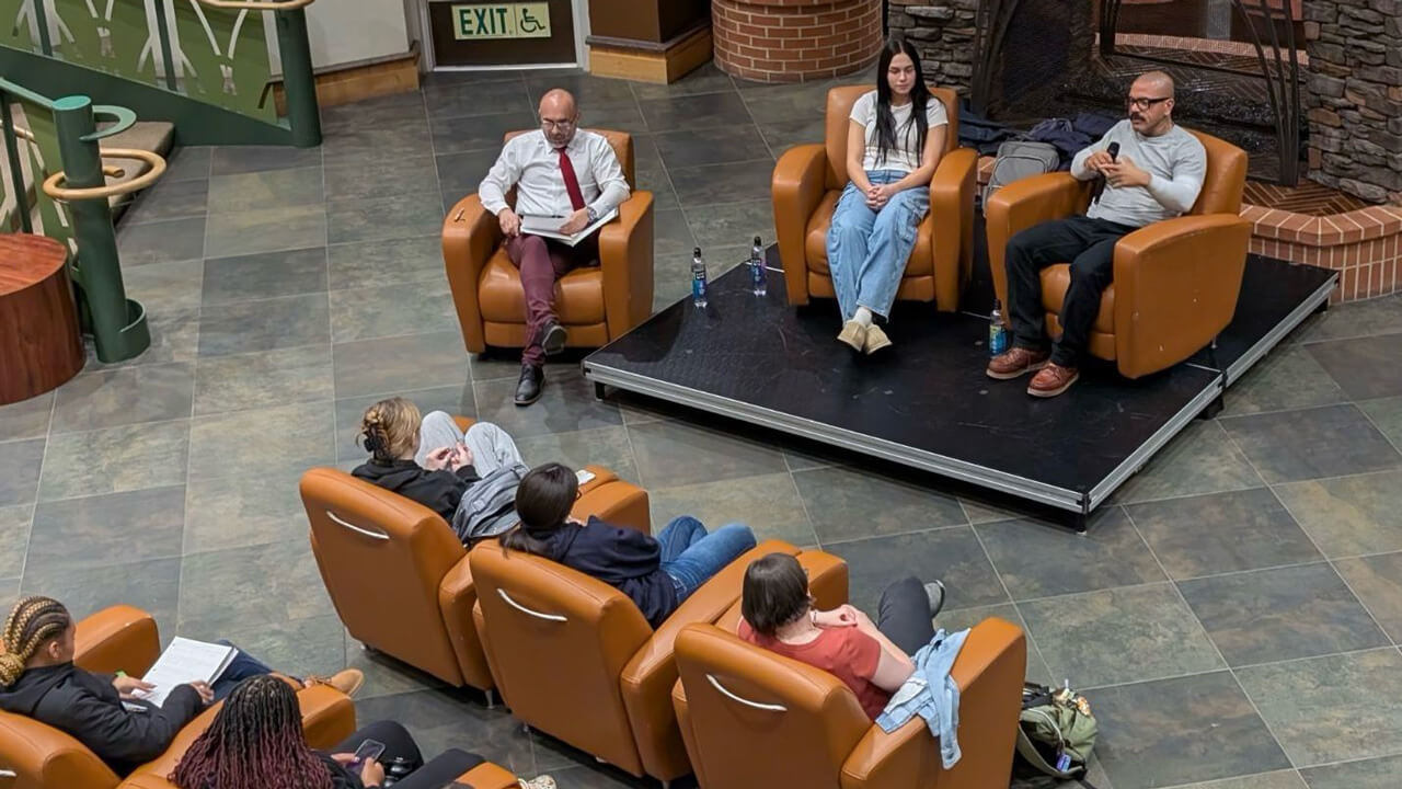 An overhead shot of the speakers and student audience members of the event sitting in chairs in the Piazza.