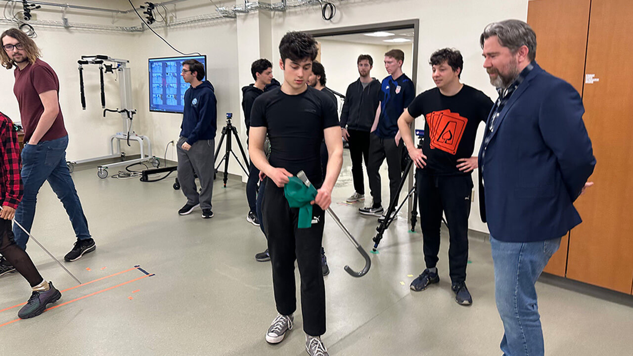 A group of students and faculty test out motion capture equipment in a classroom.