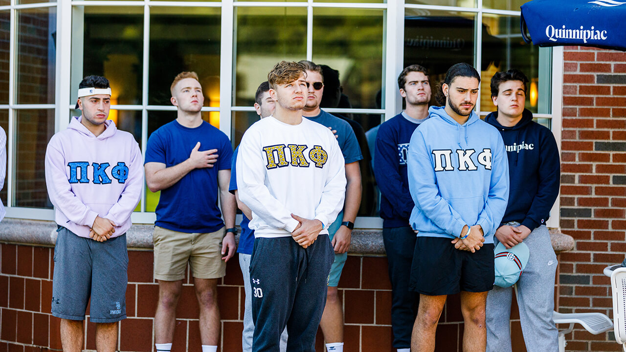 Members of a fraternity look on during the flag-raising ceremony.