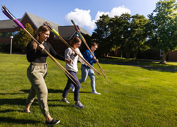 Students throw their homemade spears