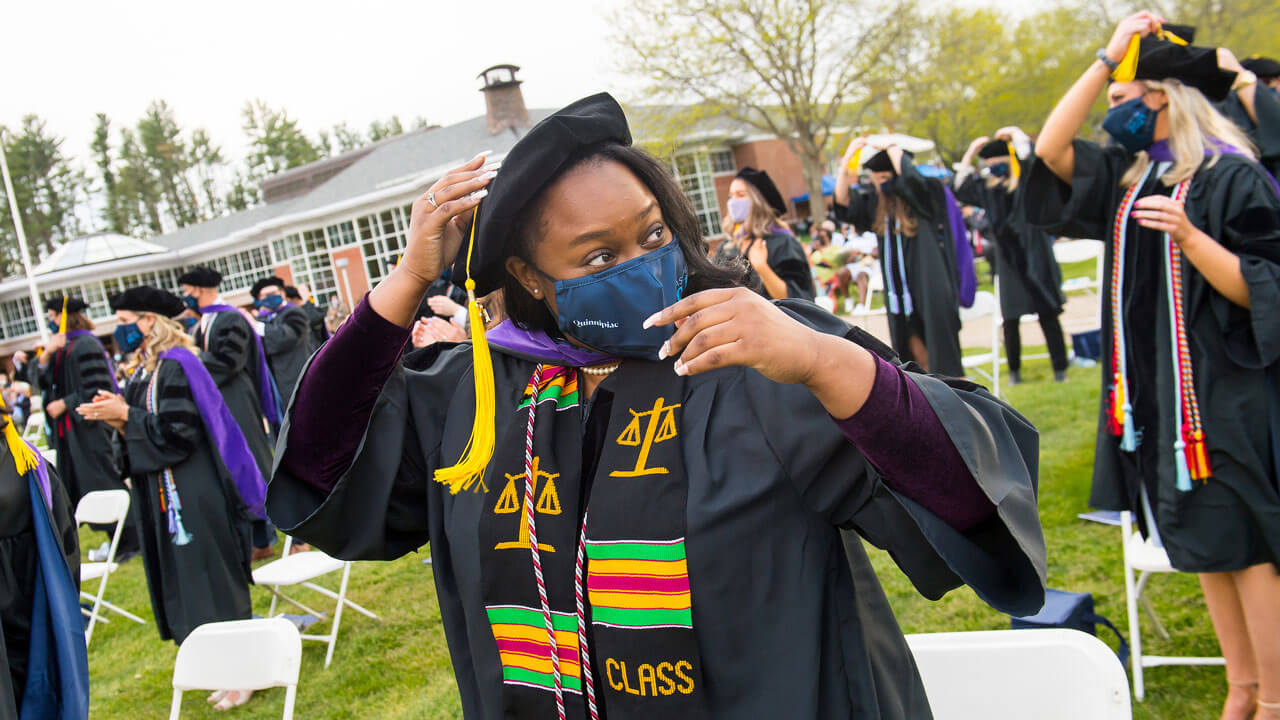 A graduate moves her tassel to the other side of her cap