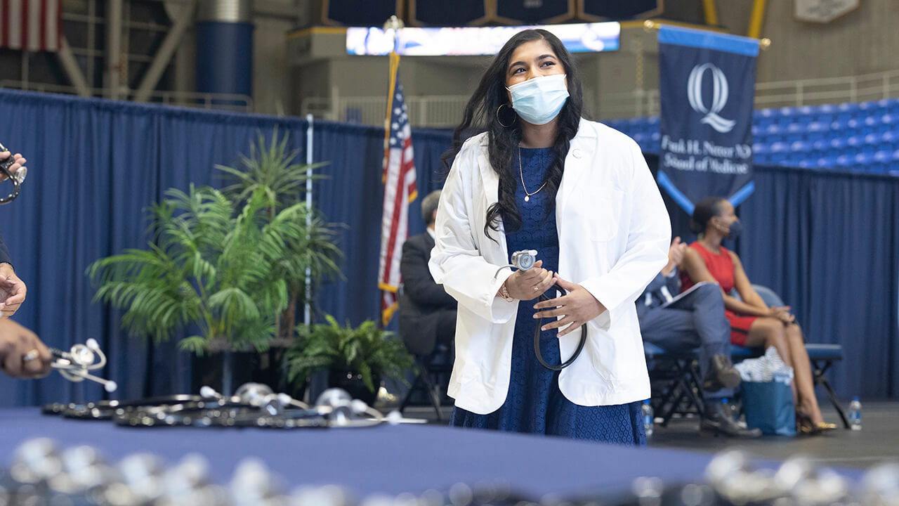 Student holds stethoscope.