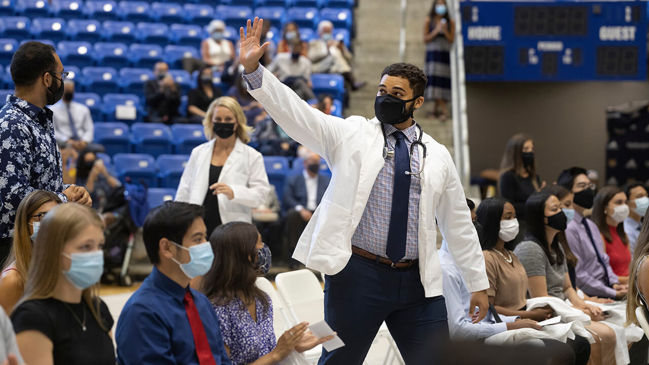 Student waves to family and friends.