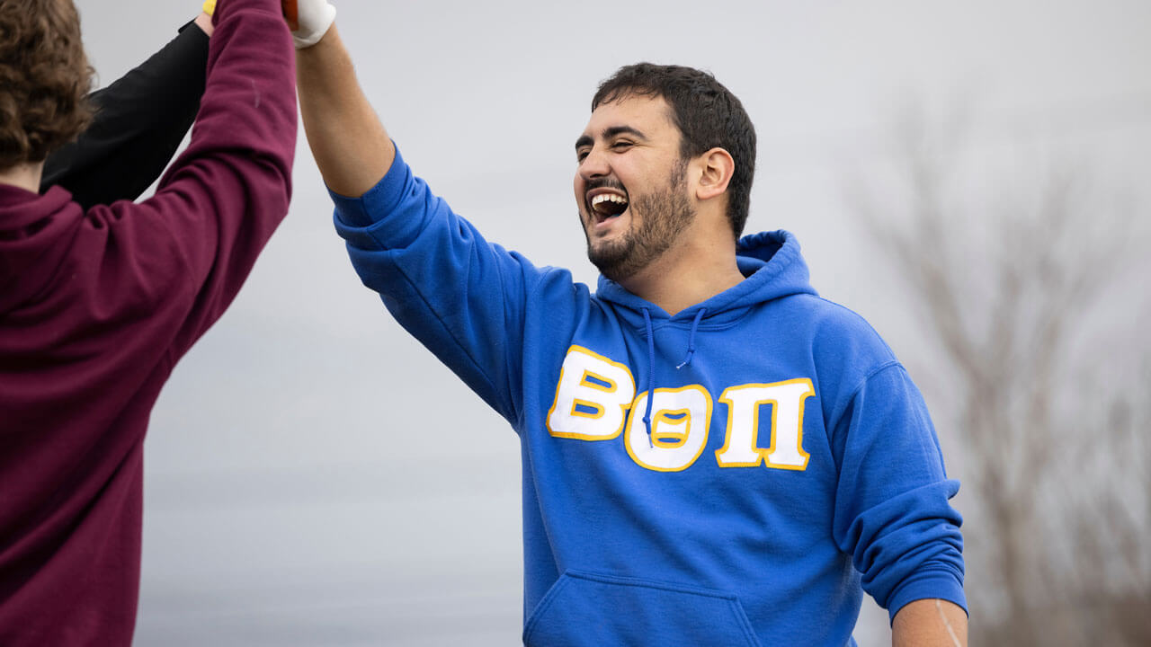 Students high-five each other at the Big Event