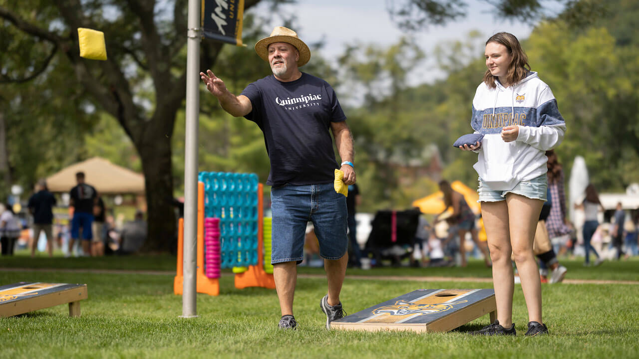 A man throws a beanbag at Bobcat Weekend.