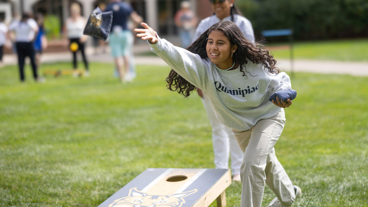 A girl tosses bean bag at Bobcat Weekend.