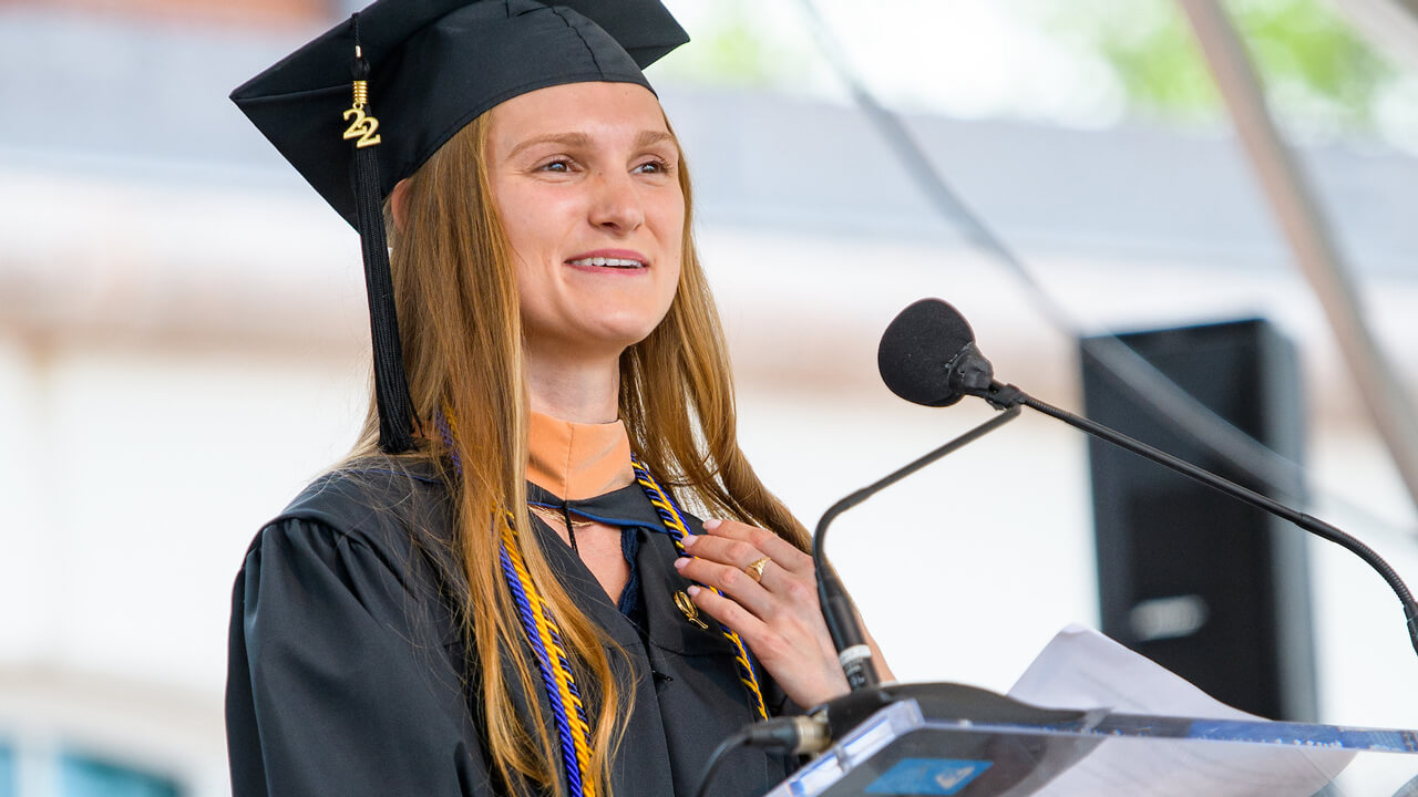 Alyssa Mesaros speaks from a podium during the graduate ceremony