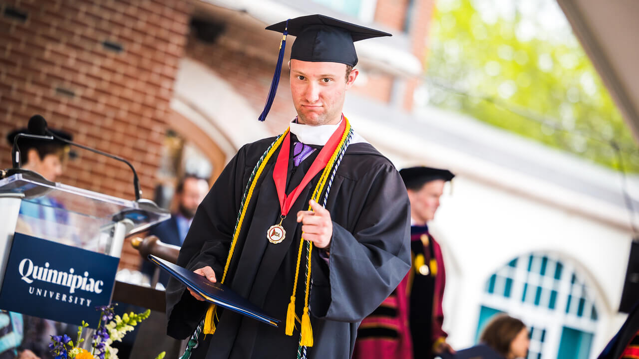 Graduate walks across the stage with his diploma