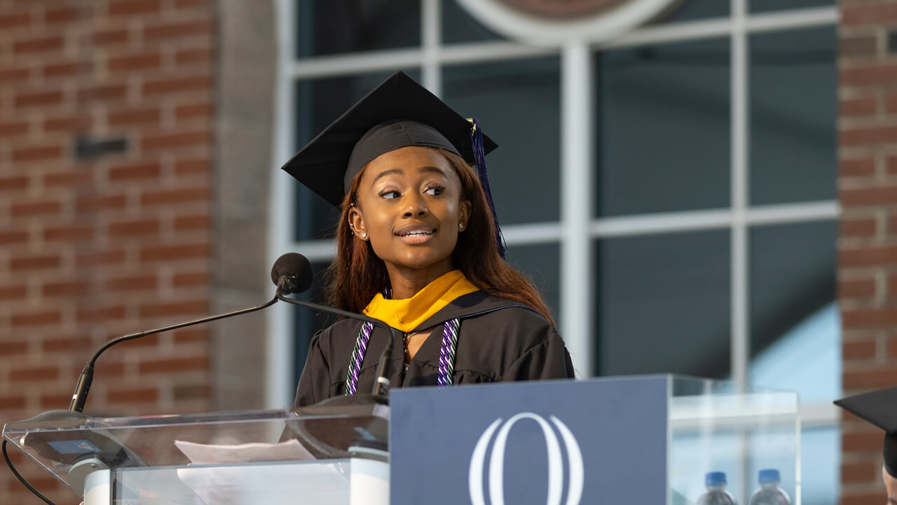 Lauren Atkinson speaks at a podium microphone during Commencement