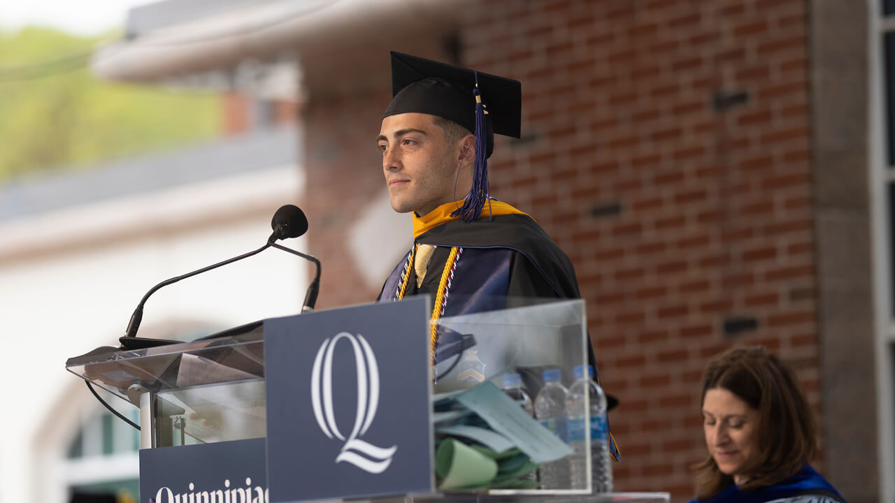 Giovanni Colatruglio speaks at a podium during Commencement