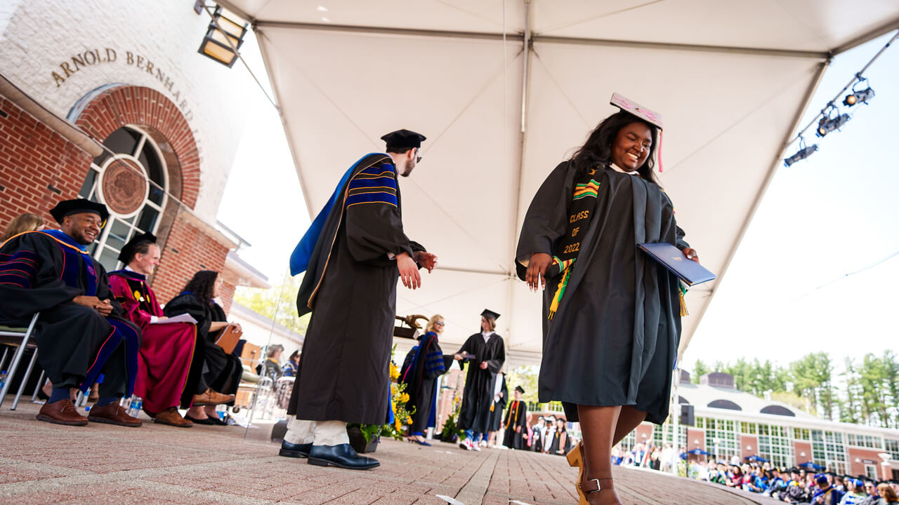 A graduate walks off the stage after receiving her diploma