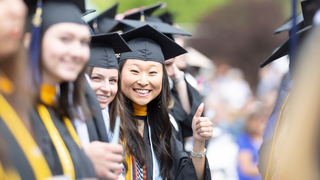 Graduates smile and give a thumbs up