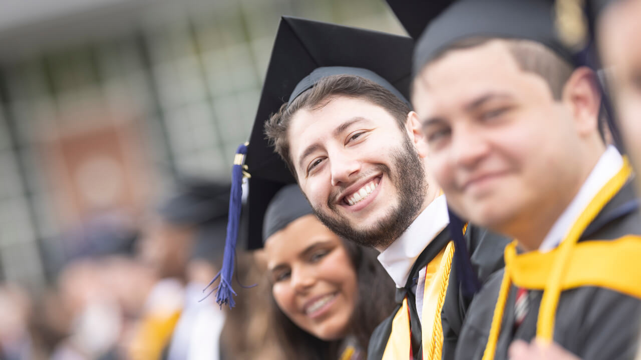 Graduates smile during the Undergraduate Commencement Ceremony