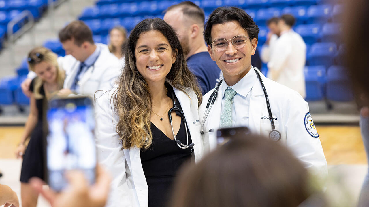 Two graduate students pose for a celebratory photo