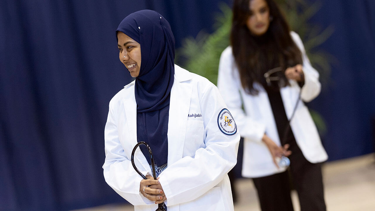 Medical graduate walks off stage with a stethoscope