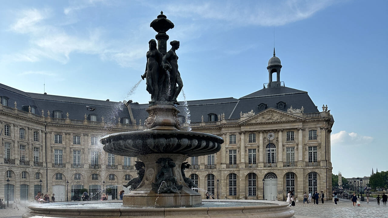 Tall water fountain with sculptures of woman at the top