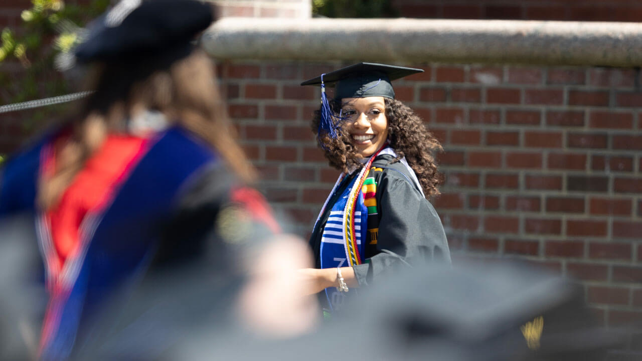 Graduate smiles looking back at audience