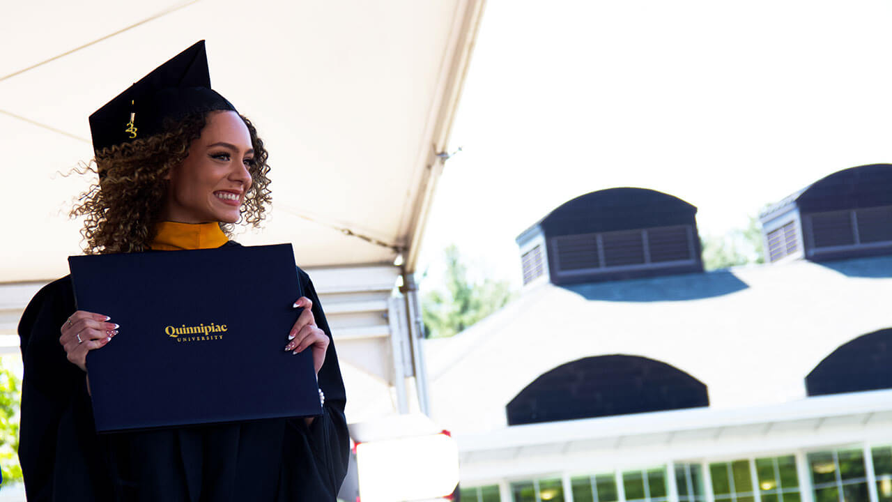 graduate looks off over the audience with her new diploma