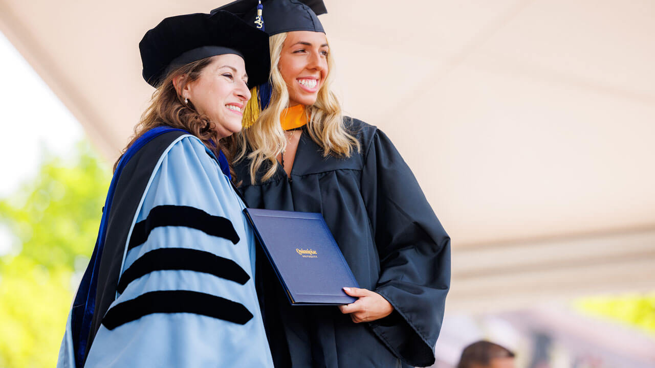 Dean Holly Raider posing with school of business graduate