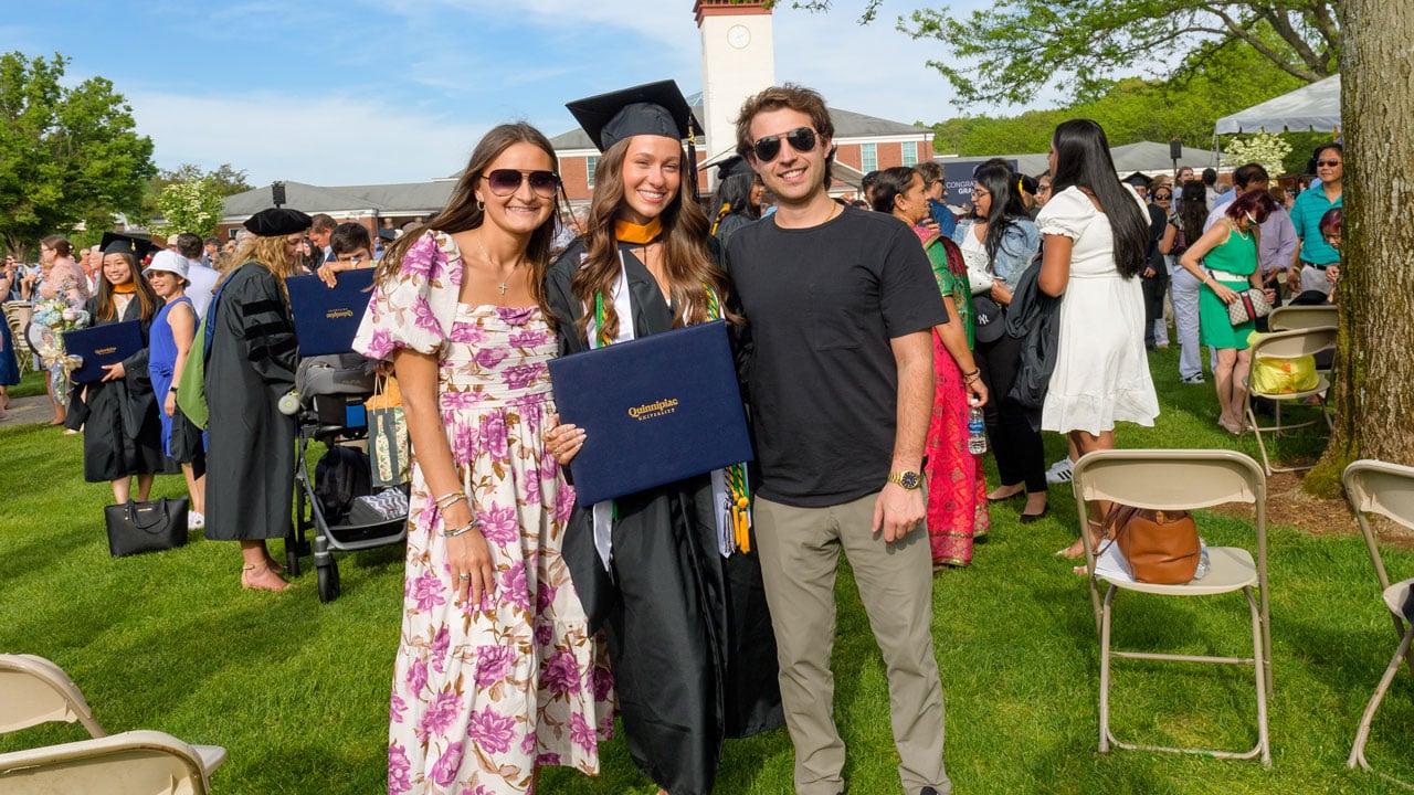 Trio posing for a family photo with a graduate