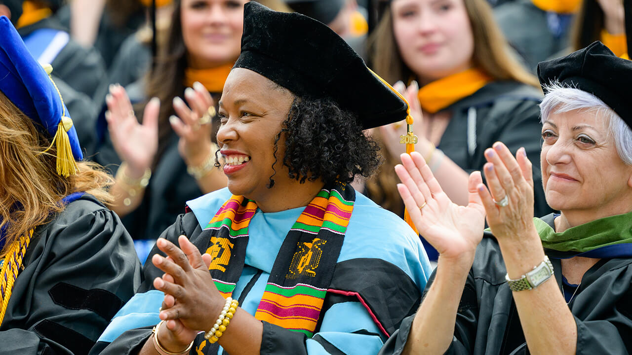 Professor claps in celebration of graduates