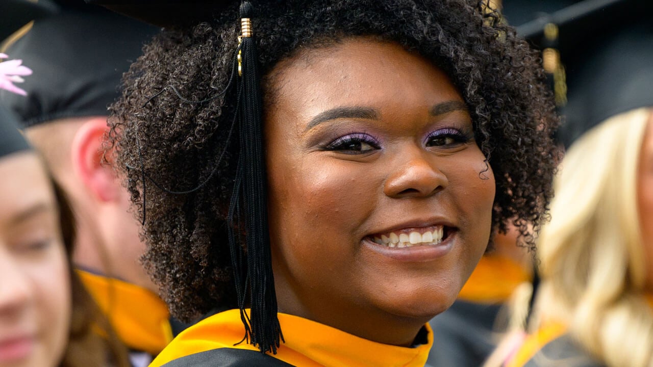 Graduate smiling ear to ear excited for commencement