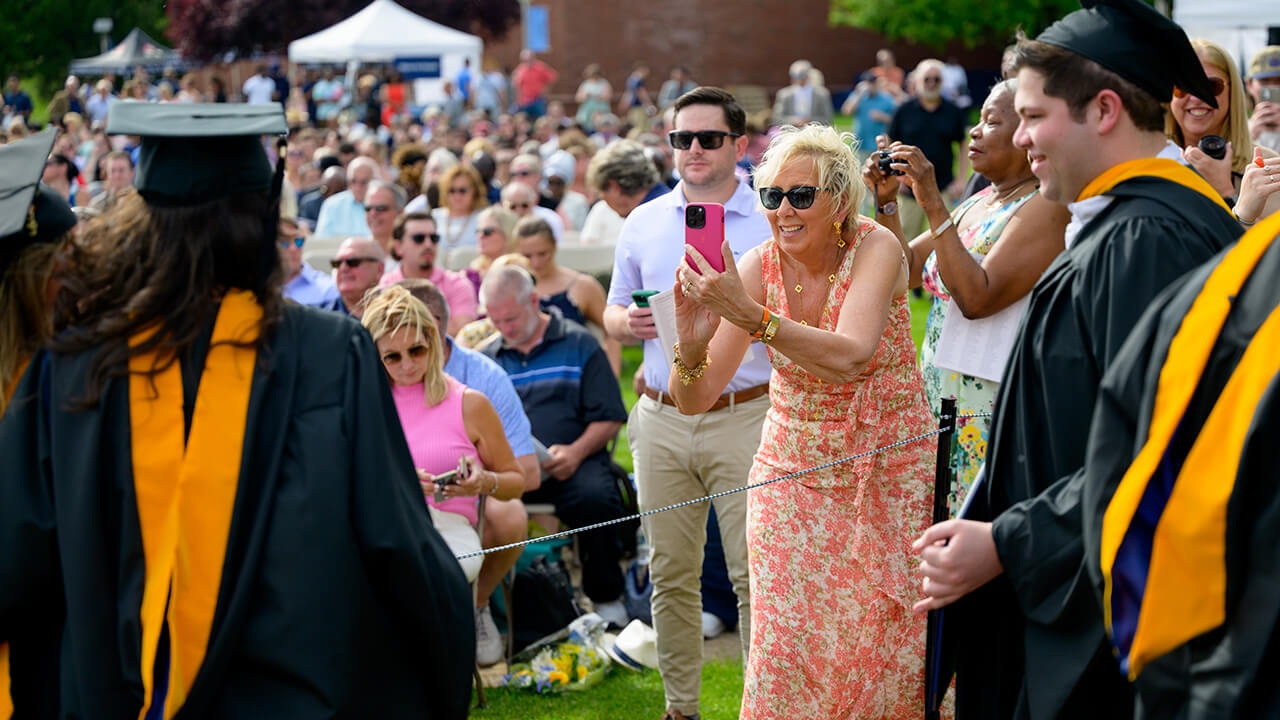 Family members capture photos of graduate after crossing stage