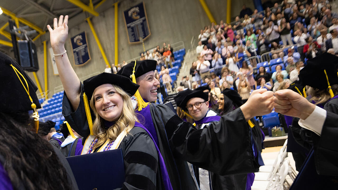 Law graduates smiling and fist bumping