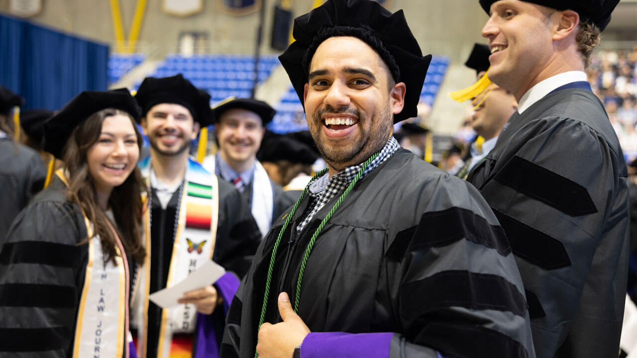 A graduate gives a thumbs up