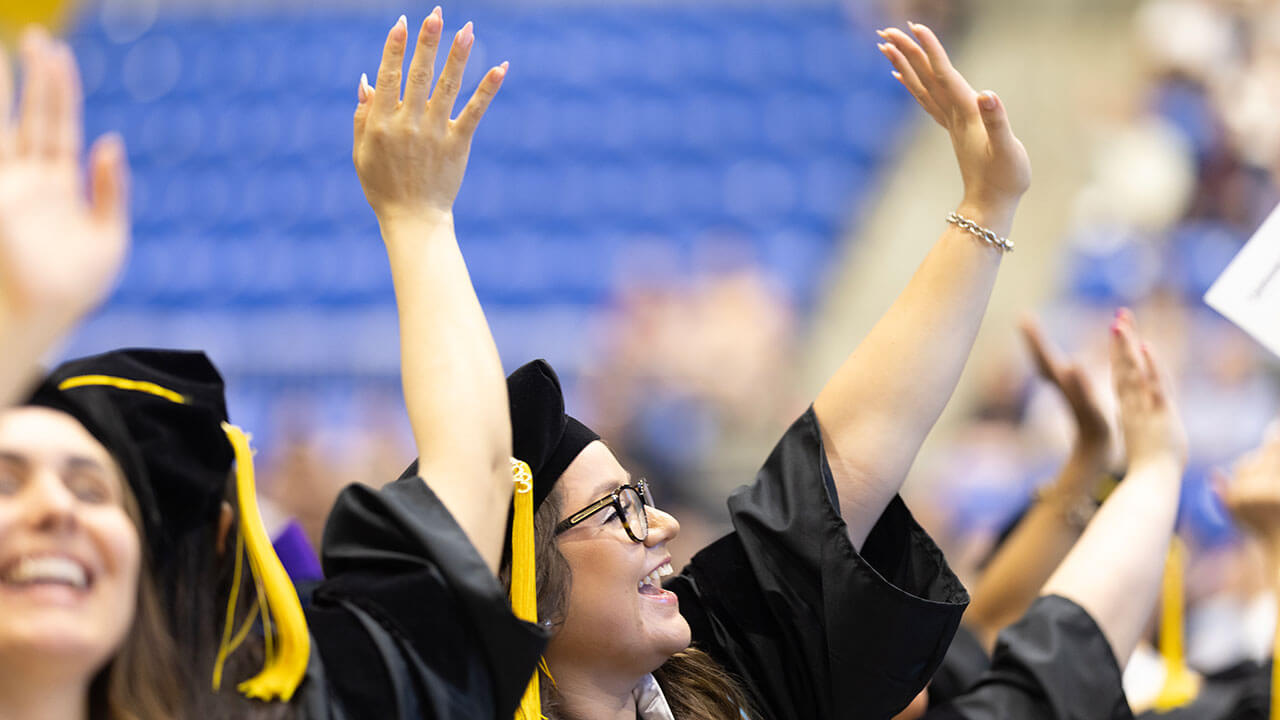 Graduates from the School of Law cheer during a ceremony