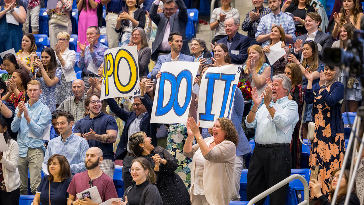 crowd holds up signs saying they did it