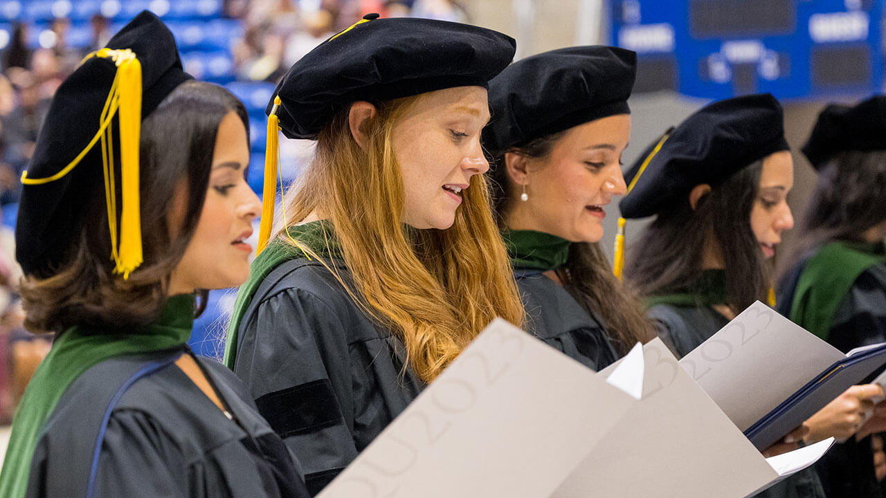 row of graduates read from their programs the oath of netter doctors