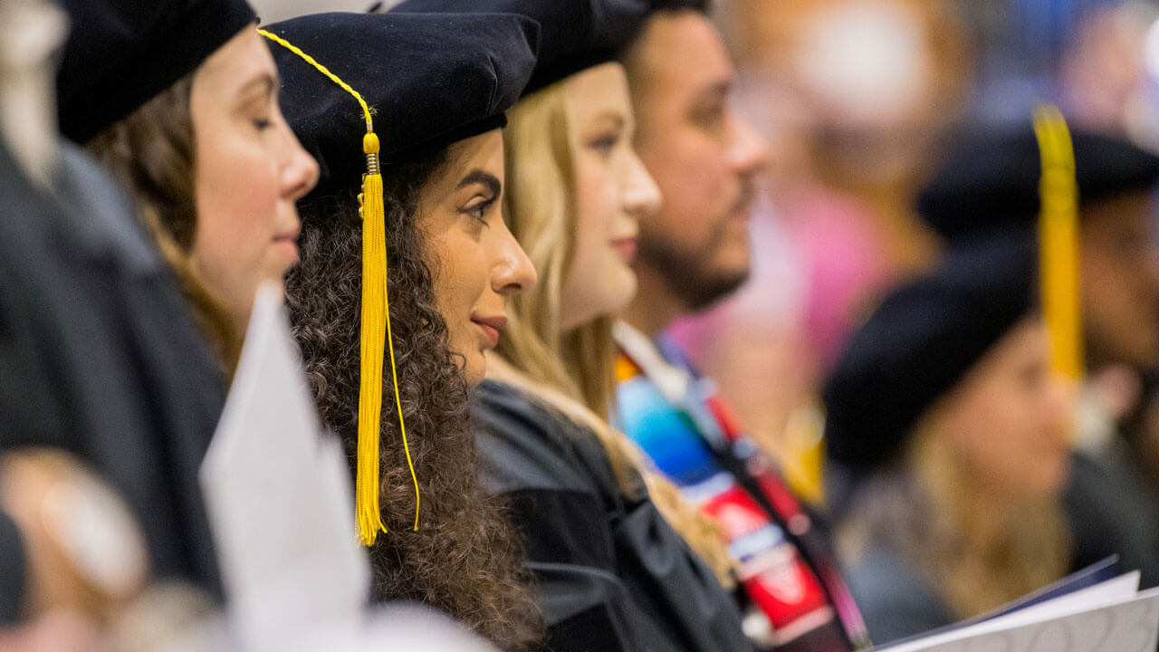 Graduates watching commencement ceremony