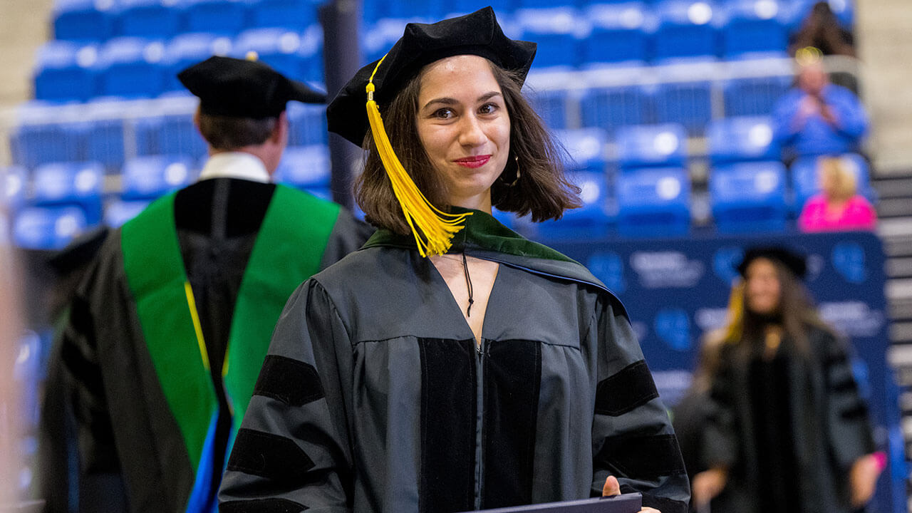 Med graduate student smiling with her diploma in hand