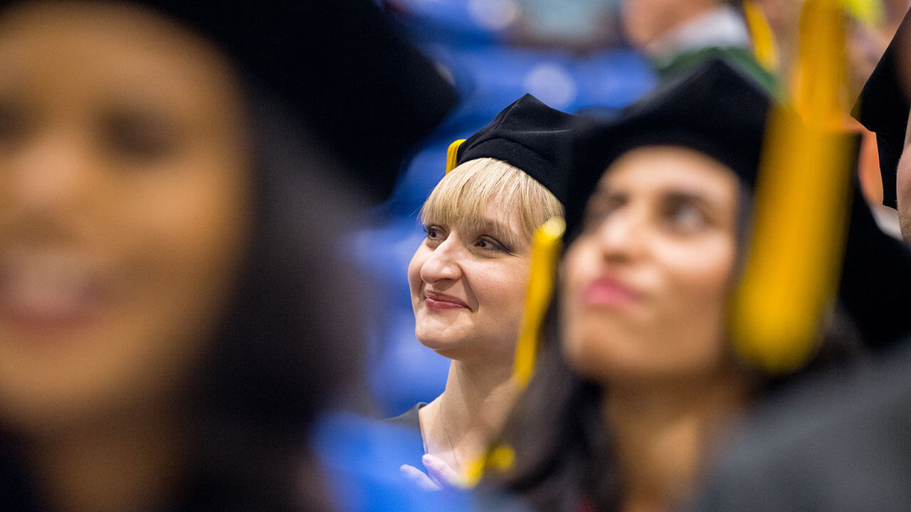 Med graduate student smiling up at the stage