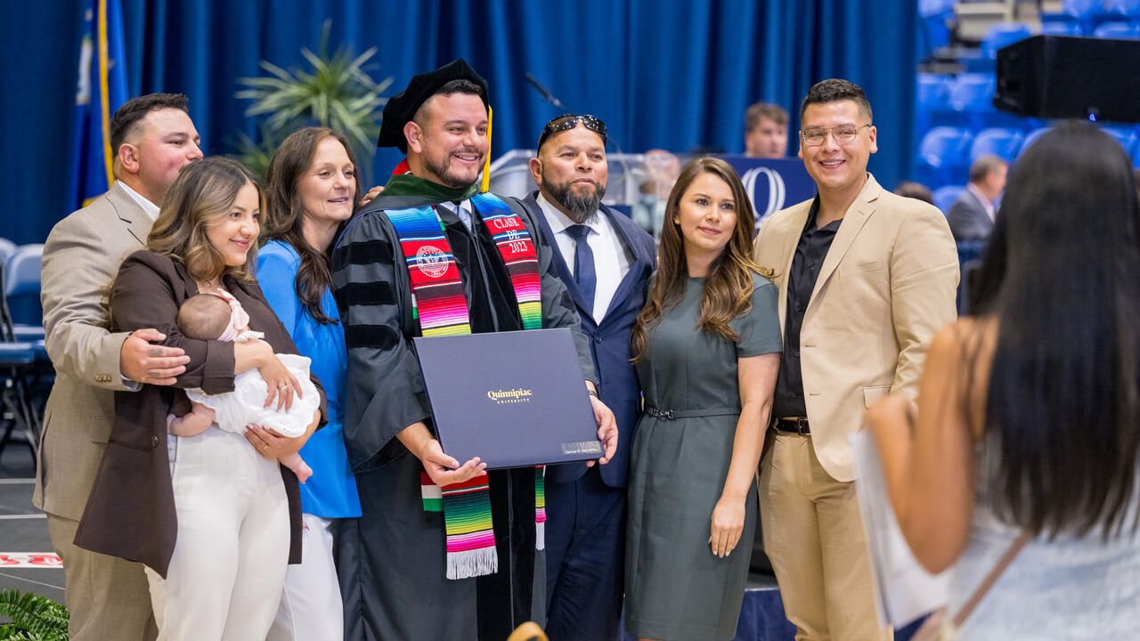 A graduate and his multi-generation family members pose for a photo