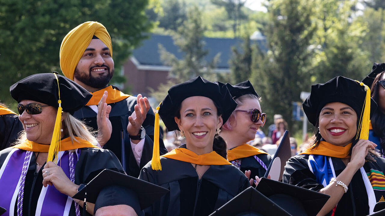 PhD candidates stand and smile