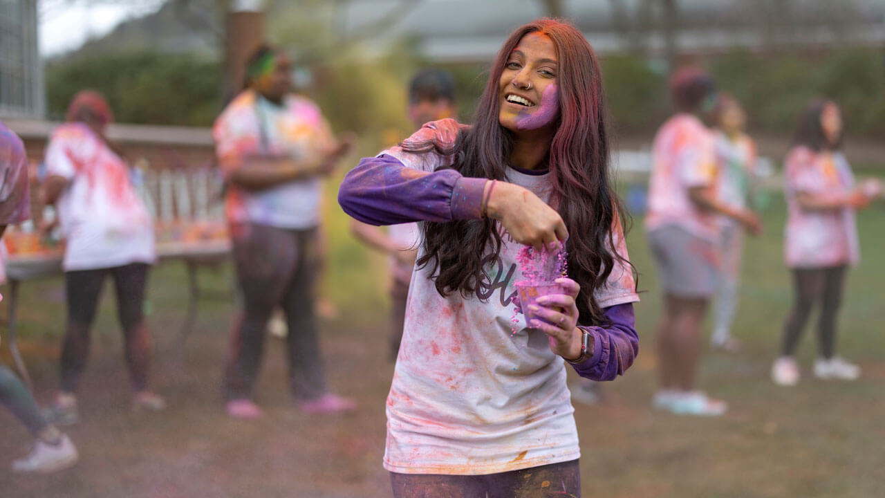 Girl brushes powder out of her hair at Holi celebration