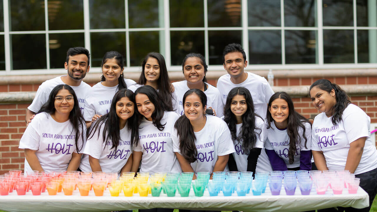 Students gather at table for Holi before celebrating