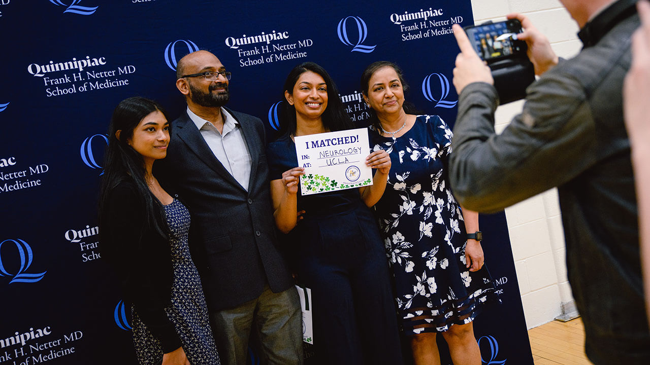 A medical school student smiles with her family.