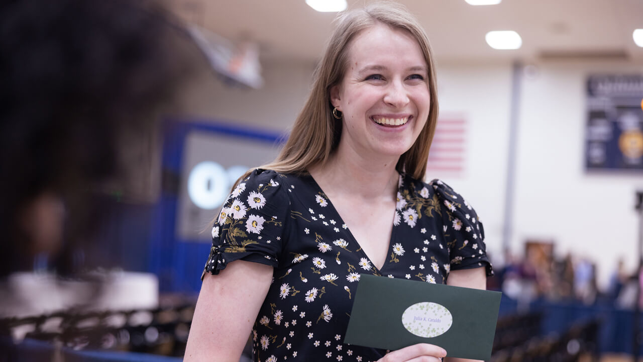 Julia Cataldo smiles as she holds her match day envelope