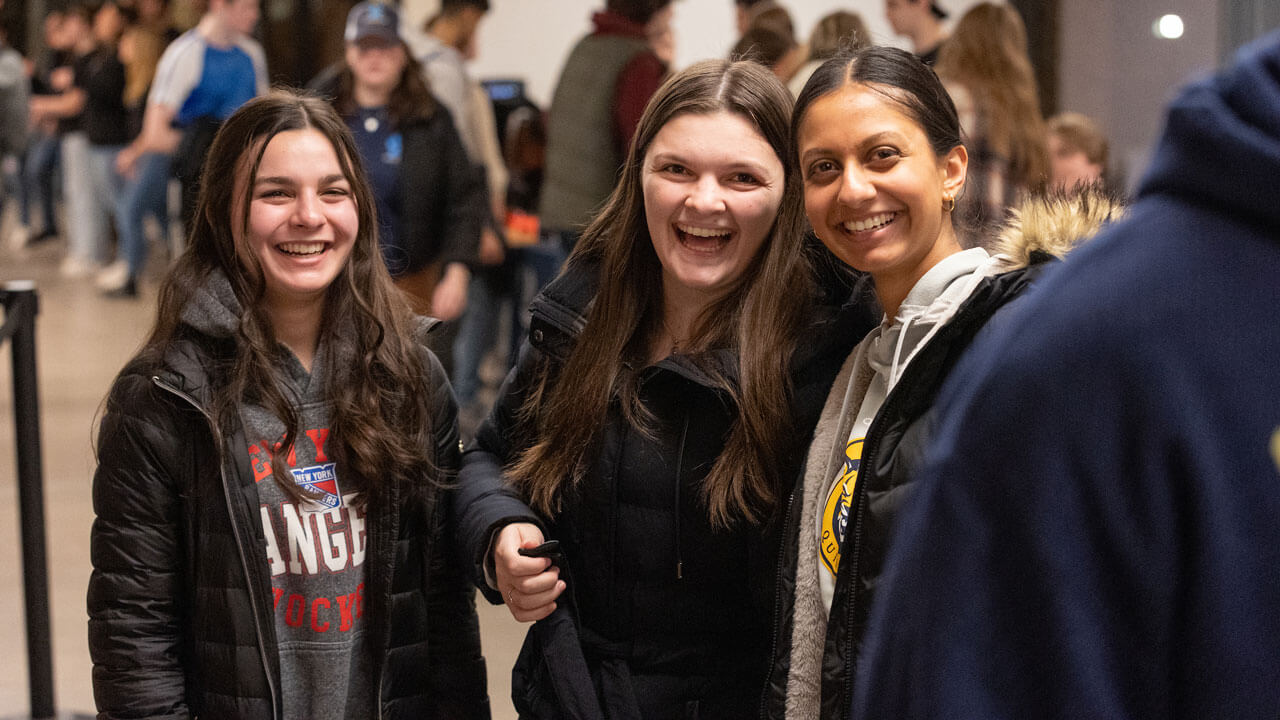 Three girls smile together at rec and wellness center opening.